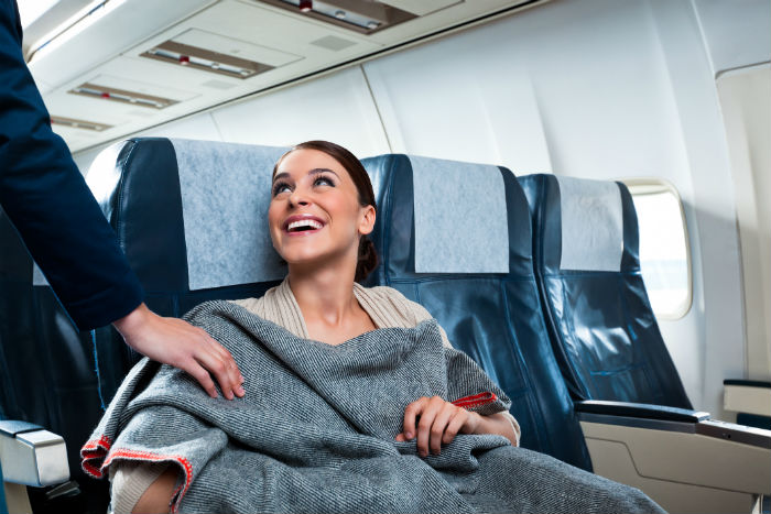 Woman Sat On Aeroplane With Blanket