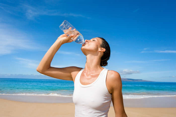 Woman Drinking Water On Beach