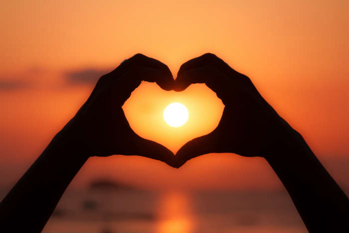 Sunset in heart shaped hands