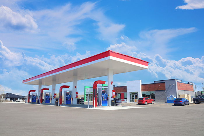 Red and white petrol station on blue sky background